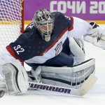 USA goaltender Jonathan Quick pushes off the puck to a teammate during the second period of a men's semifinal ice hockey game against Canada at the 2014 Winter Olympics, Friday, Feb. 21, 2014, in Sochi, Russia. (AP Photo/Julio Cortez)