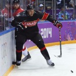 Canada forward Ryan Getzlaf seals off Austria forward Michael Raffl from the puck in the first period of a men's ice hockey game at the 2014 Winter Olympics, Friday, Feb. 14, 2014, in Sochi, Russia. (AP Photo/Mark Humphrey)