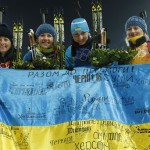 Ukraine's relay team Vita Semerenko, Juliya Dzhyma, Olena Pidhrushna and Valj Semerenko, from left, celebrate with a Ukrainian flag with writings on it after winning the gold during the women's biathlon 4x6k relay, at the 2014 Winter Olympics, Friday, Feb. 21, 2014, in Krasnaya Polyana, Russia. (AP Photo/Dmitry Lovetsky)