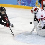  Goalkeeper Florence Schelling of Switzerland blocks Hayley Wickenheiser of Canada shot on the goal during the third period of the women's ice hockey game at the Shayba Arena during the 2014 Winter Olympics, Saturday, Feb. 8, 2014, in Sochi, Russia. (AP Photo/Petr David Josek)