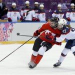 Kacey Bellamy of the United States (22) grabs Haley Irwin of Canada (21) as she tries to score during the first period of the women's gold medal ice hockey game at the 2014 Winter Olympics, Thursday, Feb. 20, 2014, in Sochi, Russia. (AP Photo/Matt Slocum)