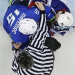 The lineman breaks up a scuffle between Slovenia defenseman Blaz Gregorc (15) and USA forward T.J. Oshie during the 2014 Winter Olympics men's ice hockey game at Shayba Arena Sunday, Feb. 16, 2014, in Sochi, Russia. (AP Photo/Matt Slocum)