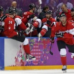 Team Canada celebrates after beating the USA 1-0 in a men's semifinal ice hockey game at the 2014 Winter Olympics, Friday, Feb. 21, 2014, in Sochi, Russia. (AP Photo/Julio Cortez)