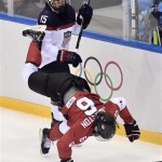 Anne Schleper of the United States, left, takes down Rebecca Johnston of Canada during the second period of the women's gold medal ice hockey game at the 2014 Winter Olympics, Thursday, Feb. 20, 2014, in Sochi, Russia. (AP Photo/The Canadian Press, Nathan Denette)
