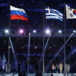 The Russian, left, Greek, center, and South Korean flags fly during the closing ceremony of the 2014 Winter Olympics, Sunday, Feb. 23, 2014, in Sochi, Russia. Pyeongchang will host the 2018 Olympic Winter Games. (AP Photo/Darron Cummings)