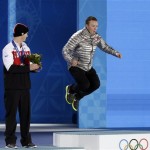 David Wise of the United States, who won the gold medal in the men's freestyle skiing halfpipe, jumps on the podium as silver medalist Mike Riddle of Canada applauds during their medals ceremony at the 2014 Winter Olympics, Wednesday, Feb. 19, 2014, in Sochi, Russia. (AP Photo/Morry Gash)