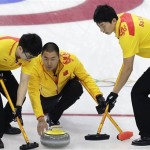 China's Liu Rui, center, delivers the rock while Zang Jialiang, left, and Ba Dexin, right, prepare to sweep the ice during the men's curling semifinal game against Canada at the 2014 Winter Olympics, Wednesday, Feb. 19, 2014, in Sochi, Russia. (AP Photo/Wong Maye-E)