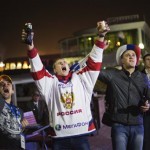 Fans cheer for Russia while watching a rebroadcast of the Cross-Country Skiing Ladies' Relay along the promenade, Saturday, Feb. 15, 2014, in central Sochi, Russia. (AP Photo/David Goldman)