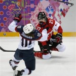 Meghan Duggan of the United States (10) collides with Tara Watchorn of Canada (27) during the first period of the women's gold medal ice hockey game at the 2014 Winter Olympics, Thursday, Feb. 20, 2014, in Sochi, Russia. (AP Photo/Julio Cortez)