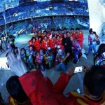 In this photo taken with a fisheye lens, athletes from China pose for photographs with volunteers during the closing ceremony of the 2014 Winter Olympics, Sunday, Feb. 23, 2014, in Sochi, Russia. (AP Photo/Darron Cummings)