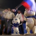 In this photo taken with a long exposure, a group of people with a Russian flag pose with Olympic mascots during an entertainment event associated with the 2014 Winter Olympics, Monday, Feb. 10, 2014, in Krasnaya Polyana, Russia. (AP Photo/Charlie Riedel)