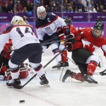 Brianna Decker of the United States (14) and Laura Fortino of Canada (8) look for a rebound during the third period of the women's gold medal ice hockey game at the 2014 Winter Olympics, Thursday, Feb. 20, 2014, in Sochi, Russia. (AP Photo/Mark Humphrey)