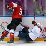 Canada forward Patrice Bergeron and USA forward Ryan Kesler collide against the boards during the third period of the men's semifinal ice hockey game at the 2014 Winter Olympics, Friday, Feb. 21, 2014, in Sochi, Russia. (AP Photo/Matt Slocum)