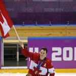 Jonathan Toews of Canada (16) skates with the Canadian flag after the medals ceremony in the men's gold medal ice hockey game at the 2014 Winter Olympics, Sunday, Feb. 23, 2014, in Sochi, Russia. Canada won gold by defeating Sweden 3-0. (AP Photo/Petr David Josek)