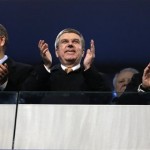 From left, United Nations Secretary-General Ban Ki-moon, International Olympic Committee President Thomas Bach, and Russian President Vladimir Putin applaud during the opening ceremony of the 2014 Winter Olympics in Sochi, Russia, Friday, Feb. 7, 2014. (AP Photo/Mark Humphrey)