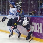 Finland defenseman Juuso Hietanen and USA forward Blake Wheeler crash the boards during the third period of the men's bronze medal ice hockey game at the 2014 Winter Olympics, Saturday, Feb. 22, 2014, in Sochi, Russia. (AP Photo/Mark Humphrey)