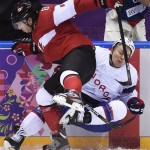  Canada defenseman Drew Doughty, left, checks Norway forward Per-Age Skroder, right, during the second period period of a men's ice hockey game at the 2014 Winter Olympics, Thursday, Feb. 13, 2014, in Sochi, Russia. Canada won 3-1. (AP Photo/The Canadian Press, Nathan Denette)
