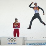 Norway's bronze medal winner Anders Bardal jumps onto the podium as Slovenia's silver medal winner Peter Prevc, left, and Poland's gold medal winner Kamil Stoch, center, applaud after the men's normal hill ski jumping final at the 2014 Winter Olympics, Sunday, Feb. 9, 2014, in Krasnaya Polyana, Russia. (AP Photo/Matthias Schrader)