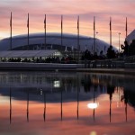 The sun sets as the Bolshoy Ice Dome is reflected in a pool of water underneath the Olympic cauldron at the 2014 Winter Olympics, Thursday, Feb. 13, 2014, in Sochi, Russia. (AP Photo/David Goldman)