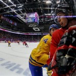 Sweden forward Patrik Berglund checks Canada forward Sidney Crosby during the second period of the men's gold medal ice hockey game at the 2014 Winter Olympics, Sunday, Feb. 23, 2014, in Sochi, Russia. (AP Photo/Julio Cortez)