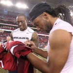 Arizona Cardinals wide receiver Larry Fitzgerald, right, autographs his jersey to give to Chicago Bears wide receiver Brandon Marshall, left, following an NFL football game,Sunday, Dec. 23, 2012, in Glendale, Ariz. The Bears won 28-13. (AP Photo/Paul Connors)
