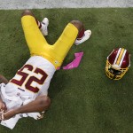 Washington Redskins' Ryan Clark covers his face with a towel after a Redskins interception was returned for a touchdown by the Arizona Cardinals during the second half of an NFL football game Sunday, Oct. 12, 2014, in Glendale, Ariz. The Cardinals defeated the Redskins 30-20. (AP Photo/Ross D. Franklin)