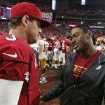 Injured Washington Redskins quarterback Robert Griffin III, right, talks with Arizona Cardinals quarterback Carson Palmer (3) after an NFL football game Sunday, Oct. 12, 2014, in Glendale, Ariz. The Cardinals defeated the Redskins 30-20. (AP Photo/Ross D. Franklin)