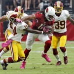 Arizona Cardinals wide receiver Larry Fitzgerald (11) breaks the tackle of Washington Redskins defensive back Trenton Robinson (34) during the first half of an NFL football game, Sunday, Oct. 12, 2014, in Glendale, Ariz. (AP Photo/Rick Scuteri)