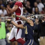 Arizona Cardinals wide receiver Larry Fitzgerald, left, catches a 24-yard pass for a touchdown as St. Louis Rams cornerback Cortland Finnegan defends during the third quarter of an NFL football game on Sunday, Sept. 8, 2013, in St. Louis. (AP Photo/Tom Gannam)