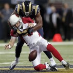 Arizona Cardinals quarterback Carson Palmer, bottom, fumbles the ball as he is sacked for a 7-yard loss by St. Louis Rams defensive end Robert Quinn during the first quarter of an NFL football game on Sunday, Sept. 8, 2013, in St. Louis. The Cardinals recovered the fumble. (AP Photo/Tom Gannam)
