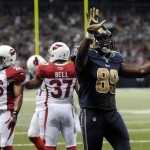 St. Louis Rams tight end Jared Cook celebrates after catching a 16-yard pass for a touchdown during the second quarter of an NFL football game as Arizona Cardinals safeties Rashad Johnson (26) and Yeremiah Bell (37) stand on the field on Sunday, Sept. 8, 2013, in St. Louis. (AP Photo/L.G. Patterson)