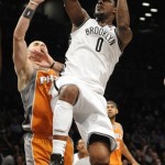 Brooklyn Nets' Andray Blatche (0) leaps over Phoenix Suns' Marcin Gortat (4) to shoot in the first half of an NBA basketball game on Friday, Jan., 11, 2013 at Barclays Center in New York. The Nets won 99-79. (AP Photo/Kathy Kmonicek)