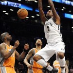 Brooklyn Nets' Andray Blatche (0) dunks a basket in front of Phoenix Suns' Jermaine O'Neal (20) and Markieff Morris, second from left, in the first half of an NBA basketball game on Friday, Jan., 11, 2013 at Barclays Center in New York. (AP Photo/Kathy Kmonicek)
