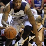 Utah Jazz's Chris Johnson, front, dribbles past a fallen Phoenix Suns' Mickey McConnell during the first half of an NBA summer league basketball game Tuesday, July 14, 2015, in Las Vegas. (AP Photo/Ronda Churchill)
