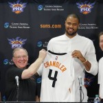 Flanked by Phoenix Suns head coach, Jeff Hornacek, right, general manager Ryan McDonough, left, and senior adviser Lon Babby, second from left, Suns' Tyson Chandler, the newly signed free agent, holds up his new uniform after being introduced to the media during a news conference Thursday, July 9, 2015, in Phoenix. (AP Photo/Ross D. Franklin)