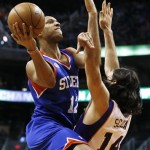 Philadelphia 76ers' Evan Turner (12) drives past Phoenix Suns' Luis Scola (14), of Argentina, during the first half of an NBA basketball game on Wednesday, Jan. 2, 2013, in Phoenix. (AP Photo/Ross D. Franklin)