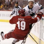 Phoenix Coyotes' Shane Doan (19) falls to the ice after trying to check San Jose Sharks' Justin Braun (61) into the boards during the first period in an NHL preseason hockey game on Friday, Sept. 27, 2013, in Glendale, Ariz. (AP Photo/Ross D. Franklin)