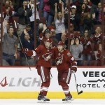 With Arizona Coyotes fans cheering in the background, Coyotes' Antoine Vermette, left, celebrates his goal against the Los Angeles Kings with teammate Shane Doan (19) during the first period of an NHL hockey game Saturday, Oct. 11, 2014, in Glendale, Ariz. (AP Photo/Ross D. Franklin)