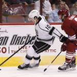 Los Angeles Kings' Mike Richards (10) tries to keep the puck away from Arizona Coyotes' Keith Yandle (3) during the first period of an NHL hockey game Saturday, Oct. 11, 2014, in Glendale, Ariz. (AP Photo/Ross D. Franklin)