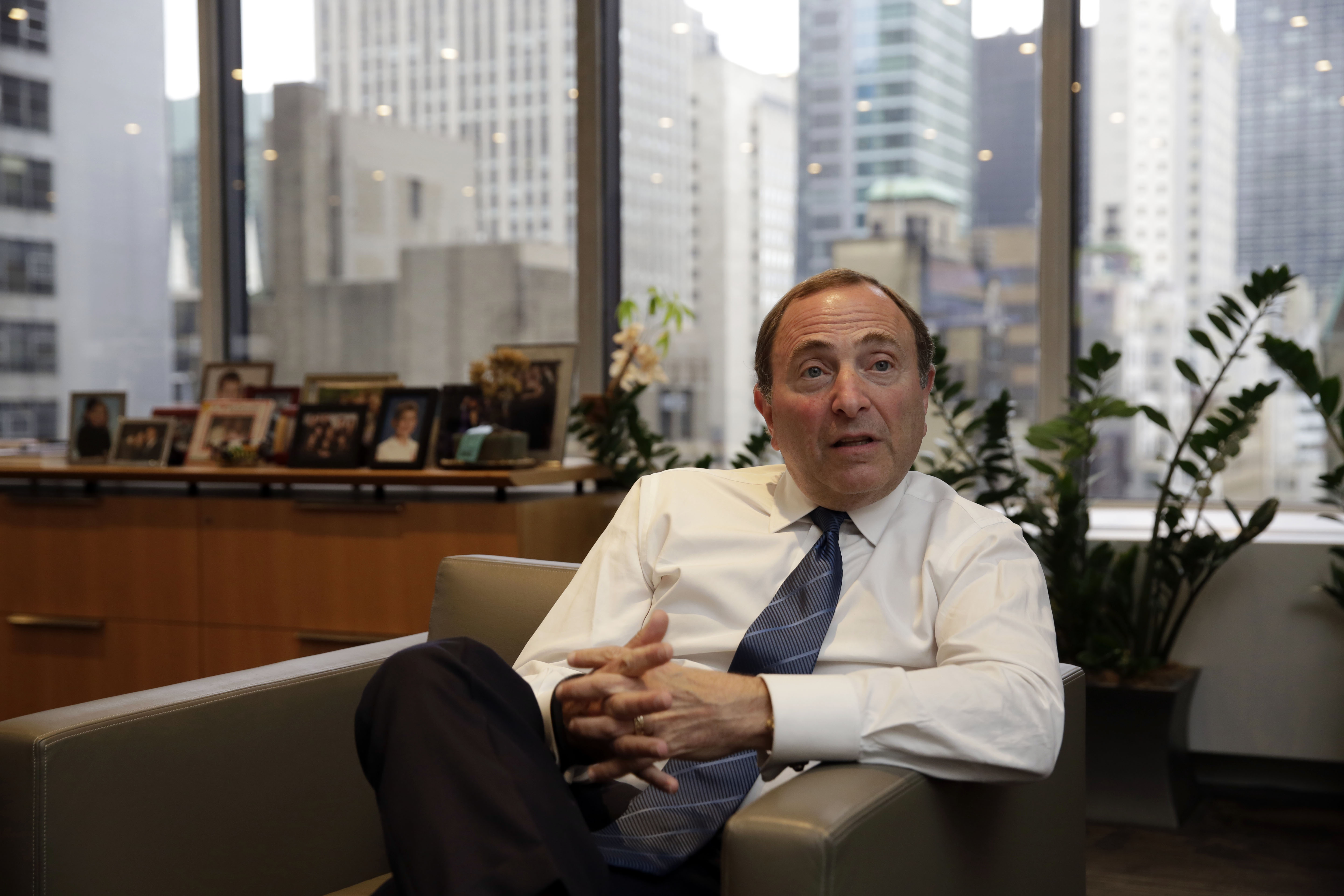 NHL Commissioner Gary Bettman (R) listens to a question during a