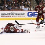 Arizona Coyotes' Devan Dubnyk (40) makes a sprawling save on a shot by Los Angeles Kings' Tyler Toffoli (73) as Coyotes' Joe Vitale (14) and Oliver Ekman-Larsson, of Sweden, look on during the first period of an NHL hockey game Saturday, Oct. 11, 2014, in Glendale, Ariz. (AP Photo/Ross D. Franklin)