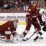 Arizona Coyotes' Devan Dubnyk, left, makes a save on a shot by Los Angeles Kings' Jordan Nolan (71) as Coyotes' Chris Summers (20) defends during the first period of an NHL hockey game Saturday, Oct. 11, 2014, in Glendale, Ariz. (AP Photo/Ross D. Franklin)