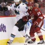 San Jose Sharks' Brent Burns (88) battles Phoenix Coyotes' Oliver Ekman-Larsson (23), of Sweden, for the puck during the first period in an NHL preseason hockey game on Friday, Sept. 27, 2013, in Glendale, Ariz. (AP Photo/Ross D. Franklin)