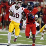 Arizona running back Davonte' Neal (19) returns a kick against Southern California linebacker Quinton Powell (18) during the first half of an NCAA college football game, Saturday, Oct. 11, 2014, in Tucson, Ariz. (AP Photo/Rick Scuteri)