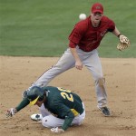 Arizona Diamondbacks second baseman Aaron Hill turns a double play over Oakland Athletics' Josh Donaldson after a ground ball by Wes Timmons during the fourth inning of a spring training baseball game Monday, March 19, 2012, in Phoenix. (AP Photo/Marcio Jose Sanchez)