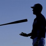 Kansas City Royals' Alex Gordon is silhouetted as he flips his bat while waiting during batting practice at ball spring training baseball Thursday, Feb. 21, 2013, in Surprise, Ariz. (AP Photo/Charlie Riedel)