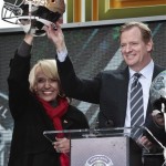 Arizona Gov. Jan Brewer, left, raise a souvenir football helmet with NFL Commissioner Roger Goodell, during a ceremony to pass official hosting duties of next year's Super Bowl to Arizona, Saturday Feb. 1, 2014 in New York. (AP Photo/Bebeto Matthews)