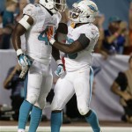 Miami Dolphins tight end Charles Clay (42) is congratulated by running back Lamar Miller (26) after Clay ran 39 yards for a touchdown during the second half of an NFL football game against the San Diego Chargers, Sunday, Nov. 17, 2013, in Miami Gardens, Fla. (AP Photo/Wilfredo Lee)