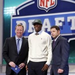Geno Smith, center, a quarterback from West Virginia, stands with NFL commissioner Roger Goodell, left, and former New York Jets wide receiver Wayne Chebrett, after being selected 39th overall by the Jets in the second round of the NFL Draft, Friday, April 26, 2013, at Radio City Music Hall in New York. (AP Photo/Jason DeCrow)