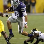  Kansas State's Jake Waters (15) is tripped by Michigan's Dymonte Thomas during the first half of the Buffalo Wild Wings Bowl NCAA college football game on Saturday, Dec. 28, 2013, in Tempe, Ariz. (AP Photo/Ross D. Franklin)